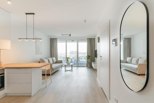 a living room with a table and a mirror at Sea View Premium Apartment I PARKING - Widok na morze in Gdynia