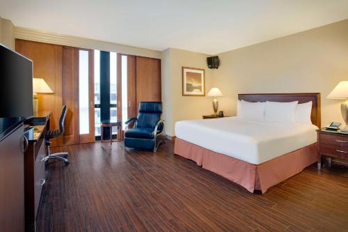 羅斯芒特的住宿－芝加哥奧黑爾機場希爾頓酒店，酒店客房带一张大床和一把椅子