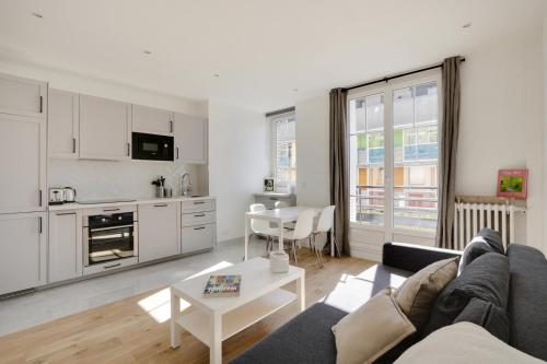 un salon avec un canapé et une table dans l'établissement Appartement Nation, à Paris