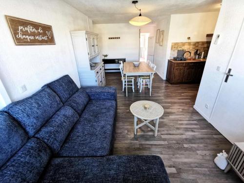 un salon avec un canapé bleu et une cuisine dans l'établissement Résidence Le Trimaran - Appartement 4 pièces - 6 couchages - PORT LEUCATE MAE-3124, à Port-Leucate