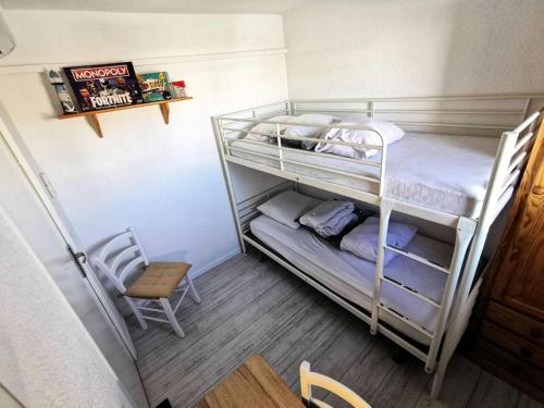 - 2 lits superposés dans une petite chambre avec une chaise dans l'établissement Résidence Le Trimaran - Appartement 4 pièces - 6 couchages - PORT LEUCATE MAE-3124, à Port-Leucate