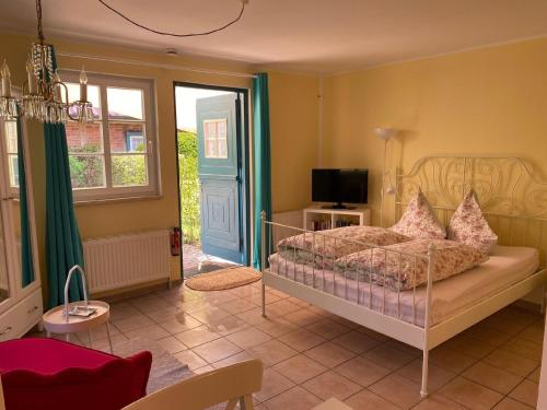 a bedroom with a bed and a television in it at Großzügiges Studio mit Küchenzeile und Badezimmer in einem kleinen Fachwerkhaus mit eigener Terrasse in Dömitz