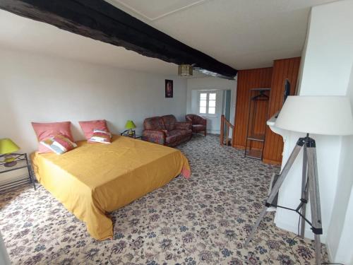 a bedroom with a bed and a chair and a lamp at La maison bleue 1 in Saint-Pierre-du-Regard