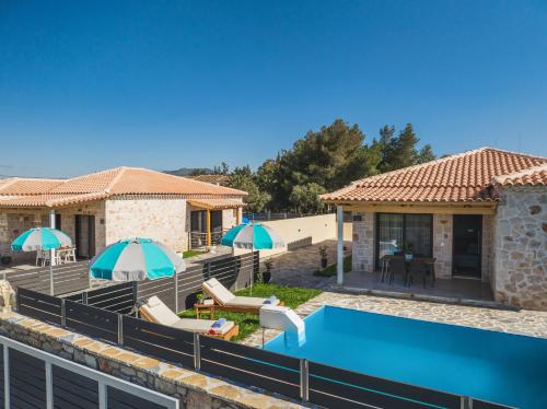 a villa with a swimming pool and a house at Mateo & Filipos Luxury Villas in Ambelókipoi