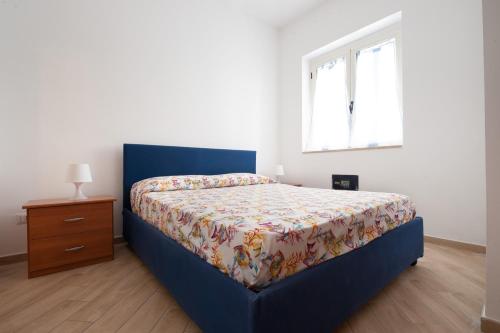 a bedroom with a bed and a dresser and a window at Settessenze Residence & Rooms in Agropoli