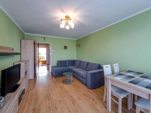 a living room with a blue couch and a table at Legnicka Budget Stay - Grysko Apartament's in Szczecin