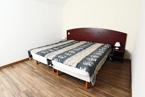 um quarto com uma cama grande e uma cabeceira em madeira em Résidence Serias - 3 Pièces pour 6 Personnes 534 em Germ