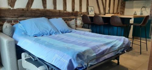 1 cama con sábanas azules y sillas en una habitación en Le Thuit - F2 Plain pied tout équipé à la ferme, en Charleval