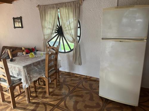 a kitchen with a table and a refrigerator at 0 es 3 Uno in Treinta y Tres