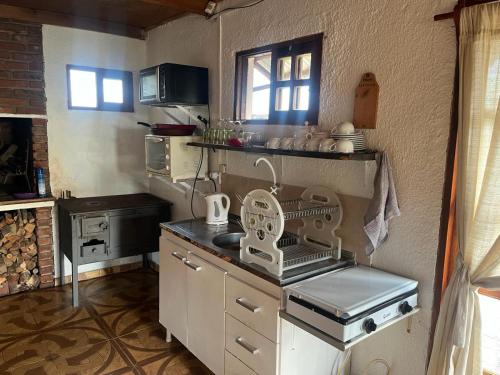 Treinta y Tres的住宿－0 es 3 Uno，厨房在柜台上设有碗碟干燥架