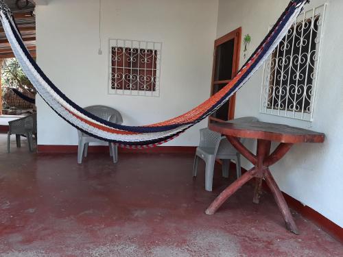 a hammock in a room with a table and chairs at Playa Casa Nohelia in Santo Domingo