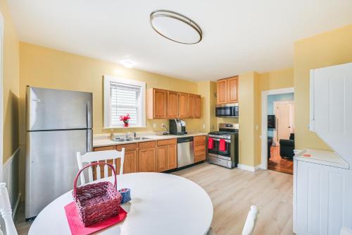 a kitchen with a white table and a refrigerator at 5 Mi to Dtwn Boston! Family-Friendly Medford Apt in Medford