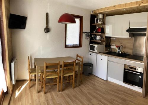 une cuisine avec une table et des chaises dans une pièce dans l'établissement Résidence Betelgeuse - 2 pièces 4 personnes 2 exposé ouest MAE-9414, à Valloire