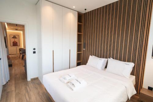 a bedroom with a large white bed with two towels on it at Volos Inn Hotel in Volos