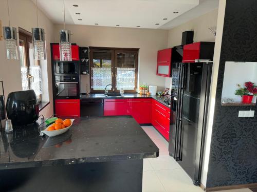 a kitchen with red cabinets and a bowl of fruit on a counter at Dom Krotoszyce in Krotoszyce