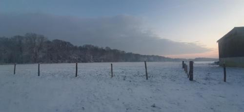 a fence in a field covered in snow at Le Thuit - F2 Plain pied tout équipé à la ferme in Charleval