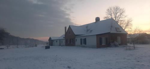 a house with snow on the ground in front of it at Le Thuit - F2 Plain pied tout équipé à la ferme in Charleval