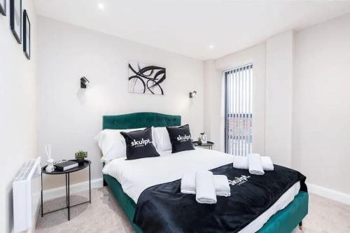 a bedroom with a large bed and a table at Luxury 1-Bed Apt City Views in the Heart of Leeds in Leeds