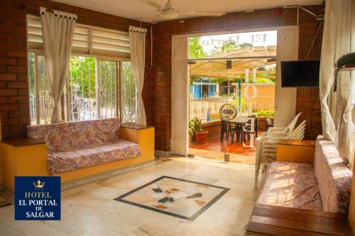 a living room with a couch and a dining room at Hotel El Portal de Salgar in Puerto Salgar