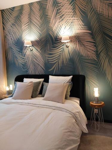 a bedroom with a large bed with a large leafy wall at Le Relais de Touraine in Abilly-Sur-Claise