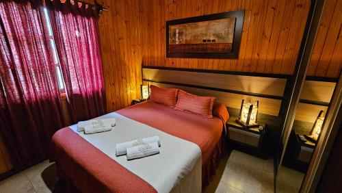 a bedroom with a bed with two towels on it at La Floresta - Cabañas con Naturaleza y Tranquilidad in Puerto Iguazú