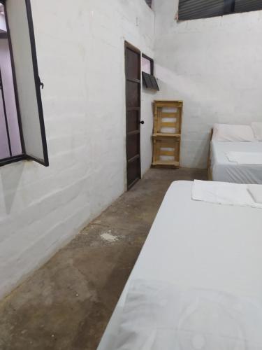 San Vicente de ChucuríにあるDe La Mora Hostal.のベッド2台とドアが備わる部屋
