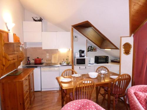 une cuisine avec une table et des chaises en bois et une cuisine avec une table dans l'établissement Résidence L'enclave - Enclave I652 MAE-3414, aux Contamines-Montjoie
