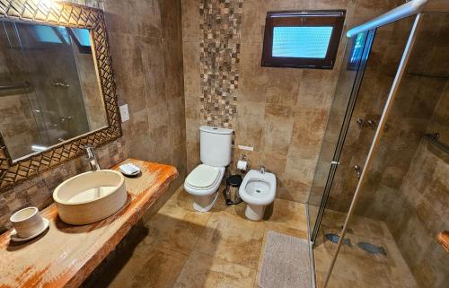 a bathroom with a toilet and a sink and a shower at La Floresta - Cabañas con Naturaleza y Tranquilidad in Puerto Iguazú