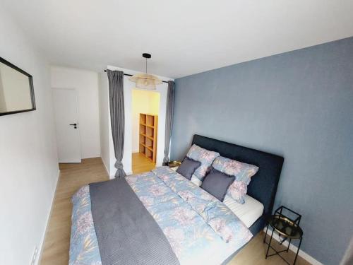 a bedroom with a bed with a blue wall at Przestronny apartament, ogródek, miejsca postojowe w garażu in Krakow