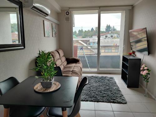 a living room with a table and a couch at Departamento en Temuco in Temuco