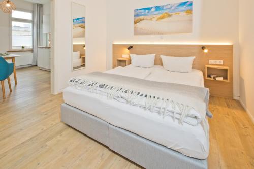 ein Schlafzimmer mit einem großen Bett in einem Zimmer in der Unterkunft Haus Menno Janssen - Ferienwohnung Bella in Norderney