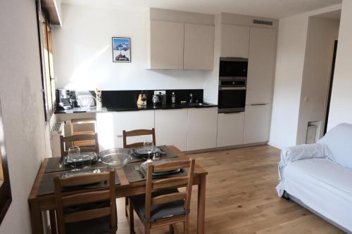 une cuisine avec une table et des chaises dans une pièce dans l'établissement Résidence Les Dryades - Les Dryades 13 MAE-9564, à Saint-Gervais-les-Bains