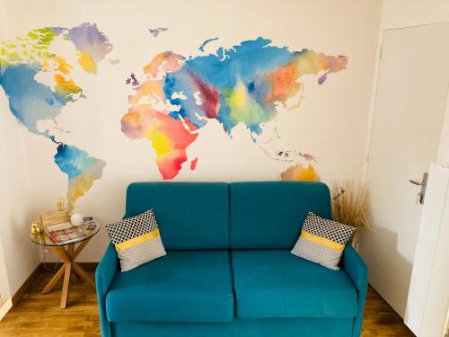 Sofá azul en una habitación con un mural del mapa mundial en Charmant logement avec jacuzzi, en Fougères