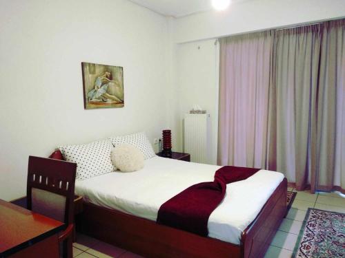 1 dormitorio con cama, mesa y ventana en Betty's sunny apartment-Athens, en Atenas