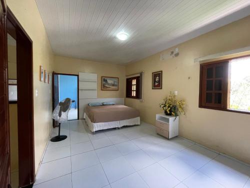 a bedroom with a bed in the corner of a room at Chácara Lameiro, Crato-CE in Crato