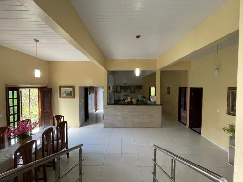 a living room with a table and a kitchen at Chácara Lameiro, Crato-CE in Crato