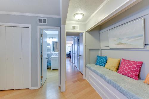 a living room with a couch with colorful pillows on it at Breezy Tybee Island Condo - 100 Yards from Beach! in Tybee Island