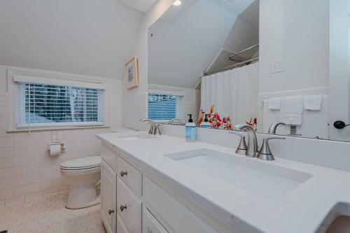 uma casa de banho branca com 2 lavatórios e um WC em Artopia Retreat and Marys Gatehouse em Greensboro