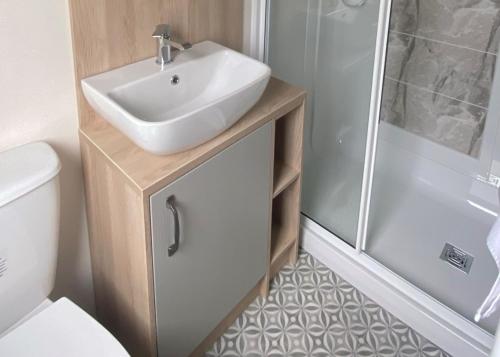 a bathroom with a sink and a shower at Seascape Bude in Bude
