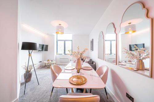 a dining room with a table and chairs and mirrors at Hayy ApartHotels Stanley Mills in Huddersfield