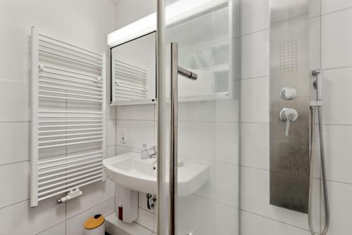 a white bathroom with a sink and a shower at City-Wohnung direkt am Markt in Goch