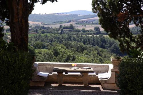 a stone bench with a table and a view at Villa Poggiano in Montepulciano