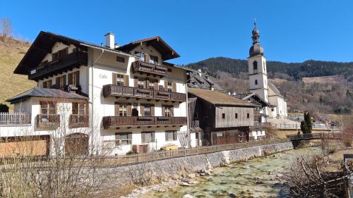 a building next to a river with a church at Ferienwohnung im Gästehaus Sieger-Brandner in Ramsau