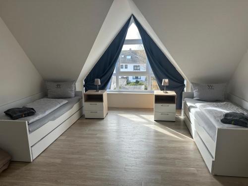 ヴァンガーオーゲにあるBoje 8; wunderschöne, großzügige Ferienwohnung für bis zu 5 Personen mit Balkon und Saunaのベッド2台と窓が備わる屋根裏部屋です。