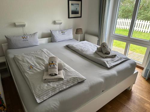 ein Bett mit Handtüchern und Schuhen darüber in der Unterkunft WangerRose - Familienwohnung für Groß und Klein und Hundefreunde in Wangerooge