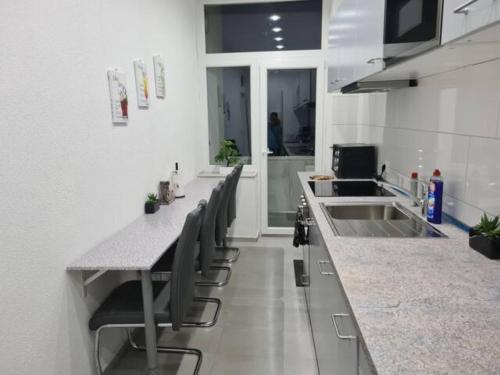 eine Küche mit einer Theke mit Stühlen und einem Waschbecken in der Unterkunft Modernes Apartment 4 mit 6 einzelnen Betten in Dortmund