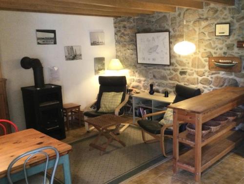 Cette chambre comprend une table, des chaises et une cuisinière. dans l'établissement Résidence P26-tregastel - Run Rouz maison classée 2 proche mer, Wifi, jardin et parking MAE-3484, à Trégastel