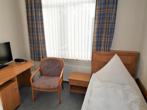 Zimmer mit einem Bett, einem Schreibtisch und einem Stuhl in der Unterkunft Villa Daheim in Borkum