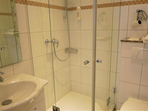 a bathroom with a shower and a sink at Villa Daheim in Borkum