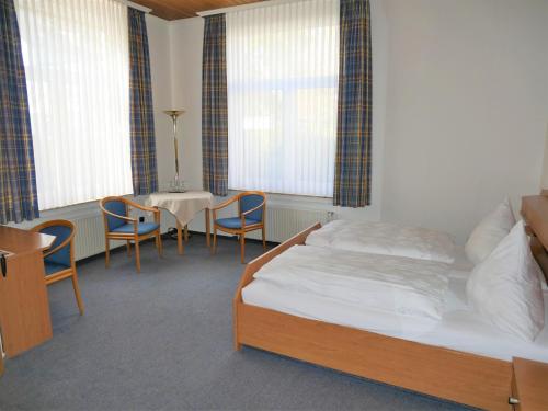 Schlafzimmer mit einem Bett, einem Tisch und Stühlen in der Unterkunft Villa Daheim in Borkum